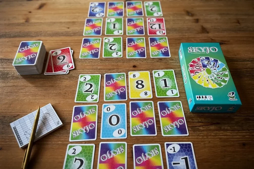 Skyjo : Pourquoi ce jeu de cartes est devenu une addiction mondiale ? Plateau de jeu Skyjo et cartes en main lors d'une partie